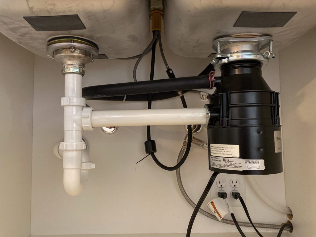 Garbage disposal unit installed under a kitchen sink in an Arvada home